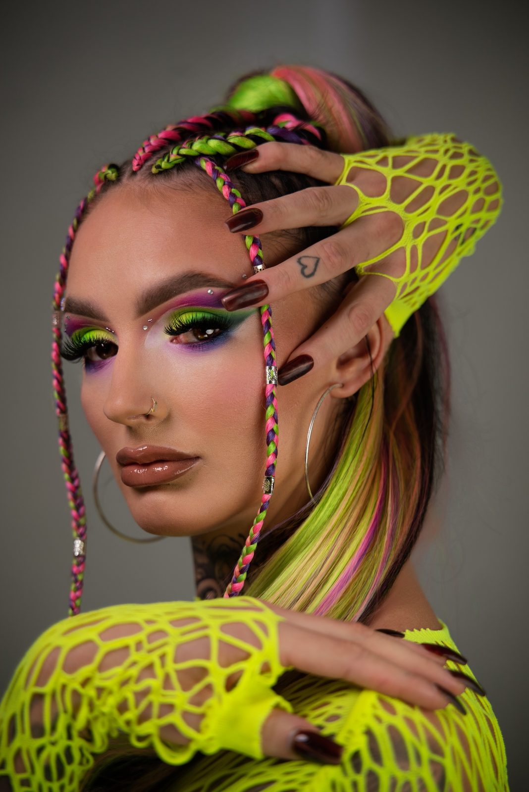De neon-look in een tweede pose, hand met netstof handschoen boven het hoofd